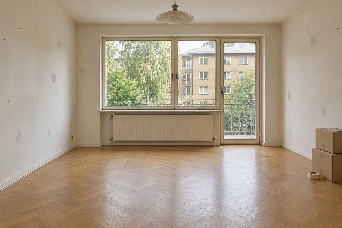 Samme lejlighed før renovering med slidt parket, spartelpletter og huller i væggene